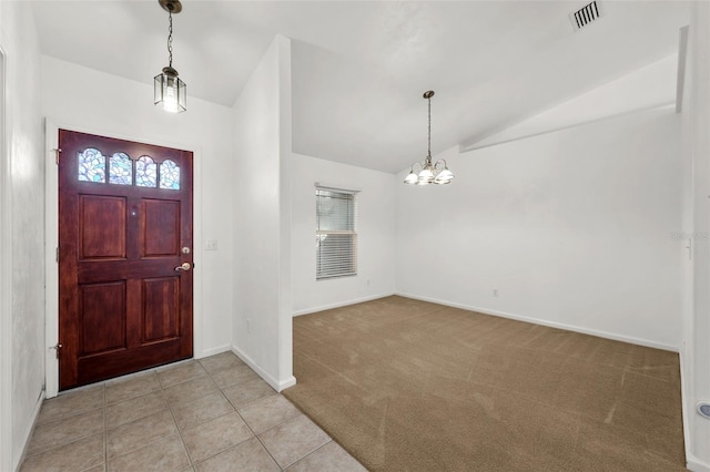 tiled entrance foyer with a chandelier and vaulted ceiling