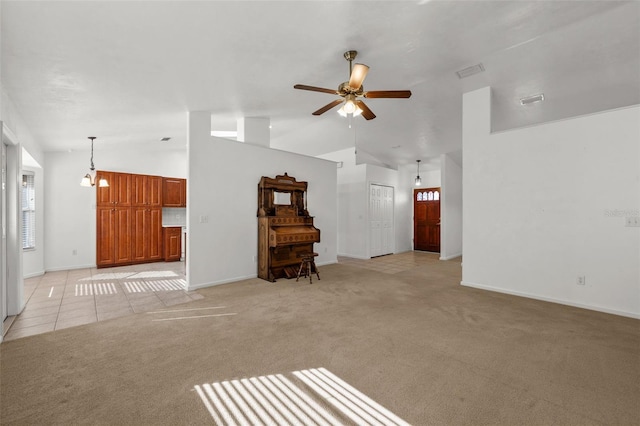 unfurnished living room with ceiling fan with notable chandelier, light colored carpet, and vaulted ceiling