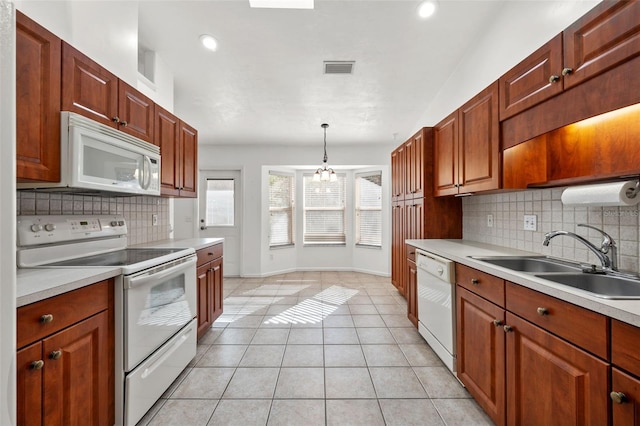 kitchen with sink, hanging light fixtures, a chandelier, white appliances, and light tile patterned flooring