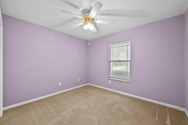 carpeted spare room featuring ceiling fan