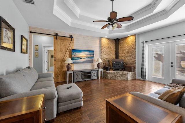 living room featuring a raised ceiling, ceiling fan, dark hardwood / wood-style flooring, and ornamental molding