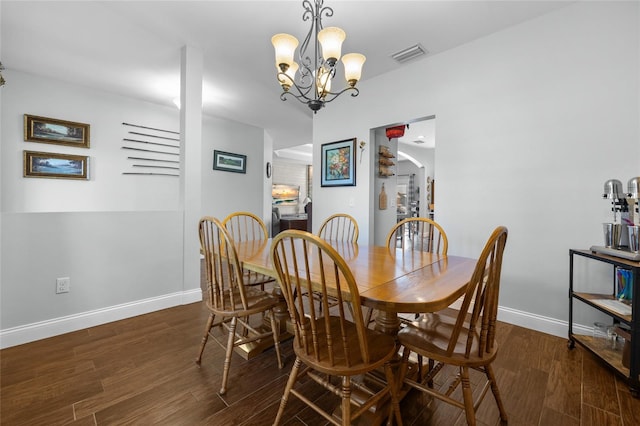 dining space featuring an inviting chandelier and dark wood-type flooring