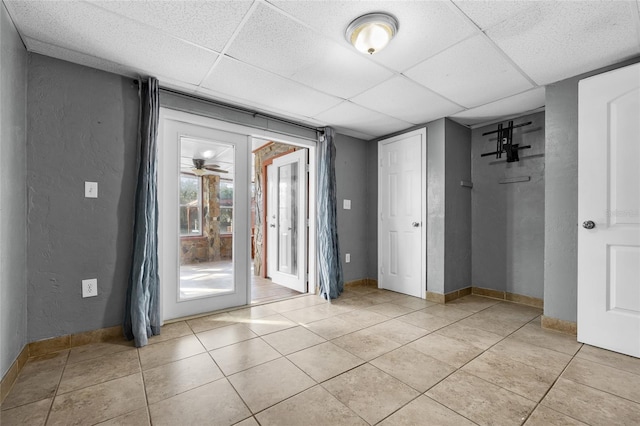 interior space with a paneled ceiling and ceiling fan