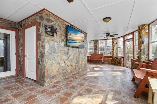 unfurnished sunroom featuring ceiling fan