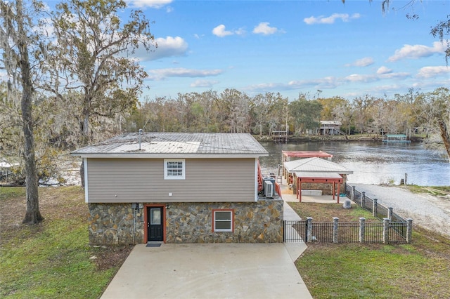 exterior space featuring a gazebo, a water view, a front yard, and central AC