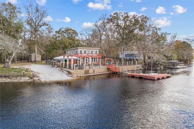 rear view of house featuring a water view and a shed