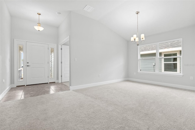 carpeted entrance foyer with a chandelier and vaulted ceiling