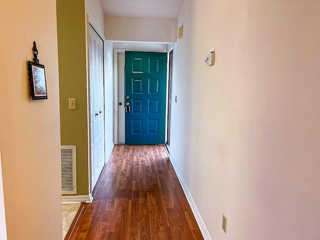 corridor featuring dark hardwood / wood-style flooring and a textured ceiling