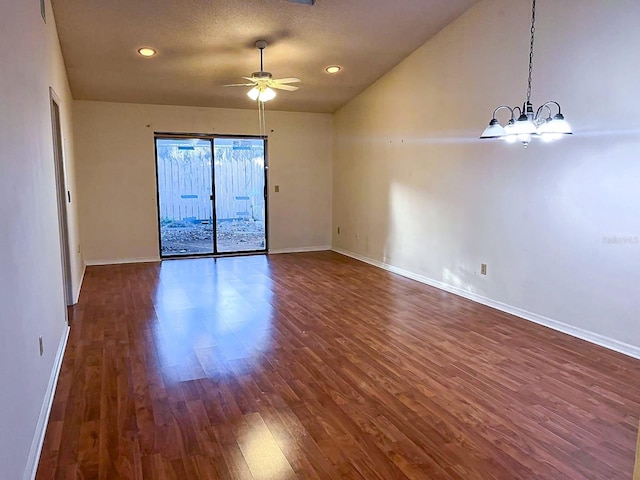 unfurnished room with ceiling fan with notable chandelier and dark hardwood / wood-style floors