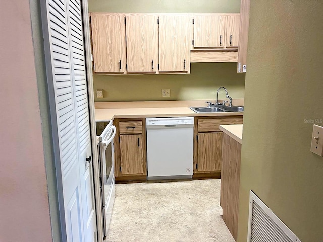 kitchen with light brown cabinets, white appliances, and sink