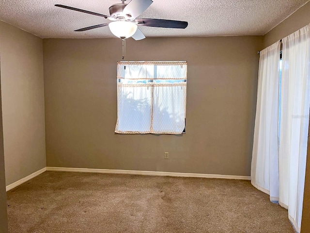 carpeted spare room with ceiling fan and a textured ceiling