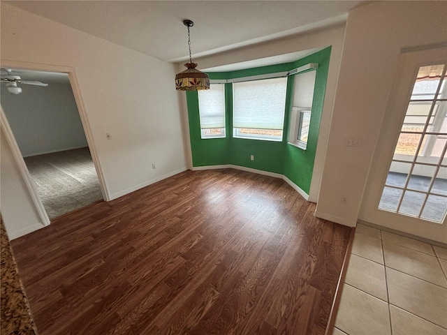 spare room with ceiling fan, wood-type flooring, and a baseboard heating unit