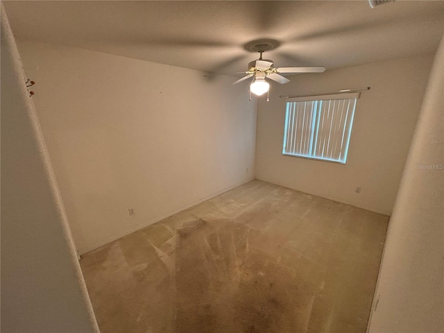 empty room featuring ceiling fan and light colored carpet