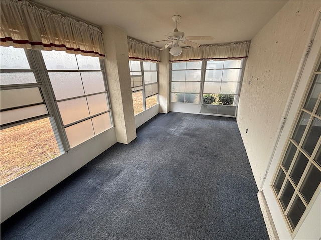 unfurnished sunroom featuring ceiling fan