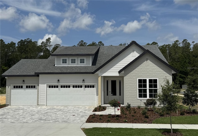 804 SW 144th Dr, Newberry, FL 32669 - view of front of home featuring decorative driveway, an attached garage, and a shingled roof