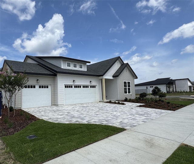 804 SW 144th Dr, Newberry, FL 32669 - view of front of home with decorative driveway, a garage, roof with shingles, and a front lawn