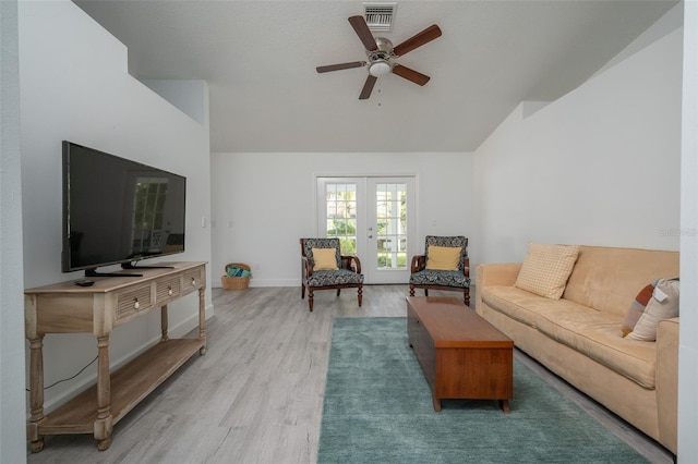 living room with lofted ceiling, light hardwood / wood-style floors, french doors, and ceiling fan