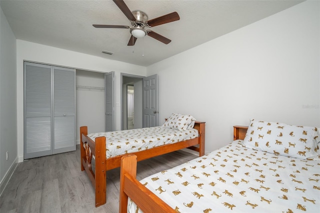 bedroom featuring wood-type flooring, ceiling fan, and a closet