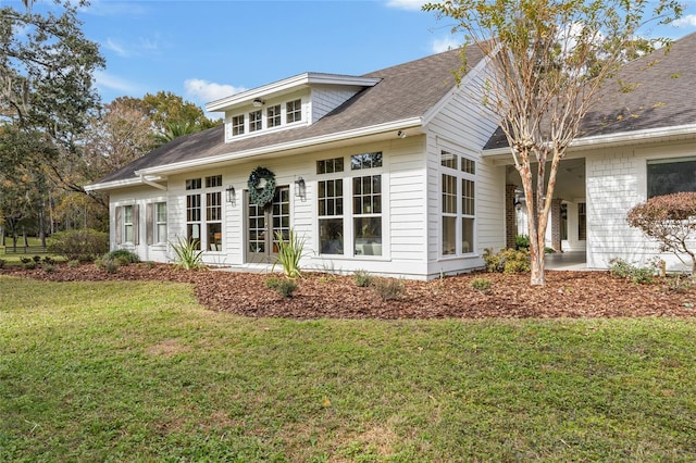 rear view of property featuring a patio area and a yard