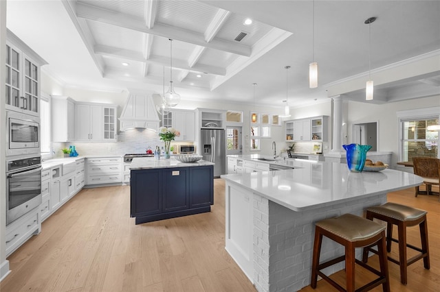 7106 NW 18th Ave, Gainesville, FL 32605 - kitchen with premium range hood, appliances with stainless steel finishes, a large island, and light wood-type flooring
