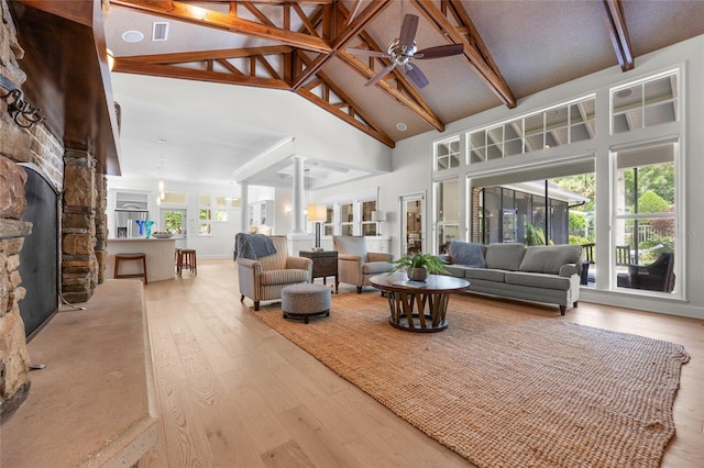 7106 NW 18th Ave, Gainesville, FL 32605 - living area with high vaulted ceiling, a fireplace, ceiling fan, decorative columns, and hardwood / wood-style floors