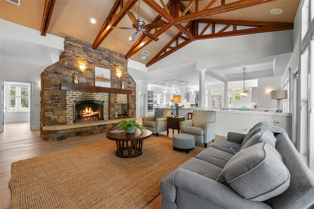 7106 NW 18th Ave, Gainesville, FL 32605 - living room with high vaulted ceiling, beam ceiling, a fireplace, wood finished floors, and ceiling fan
