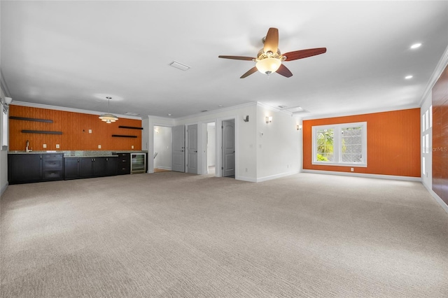 7106 NW 18th Ave, Gainesville, FL 32605 - unfurnished living room featuring wet bar, a sink, beverage cooler, light colored carpet, and ornamental molding