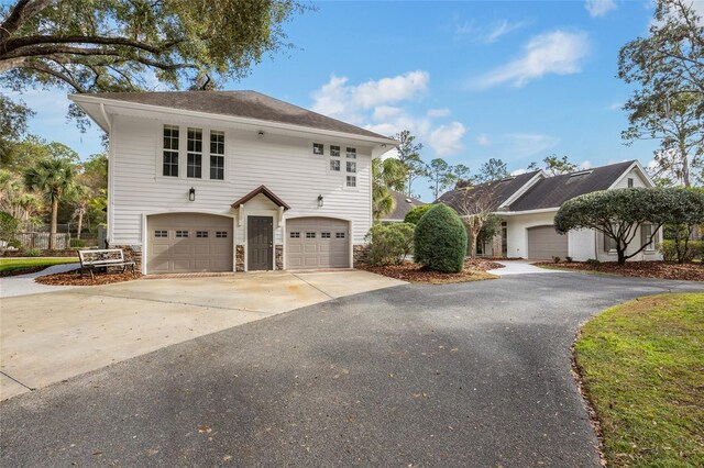 7106 NW 18th Ave, Gainesville, FL 32605 - view of front of house featuring stone siding, driveway, and a garage