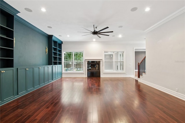 unfurnished living room with a high end fireplace, dark hardwood / wood-style flooring, ceiling fan, and crown molding