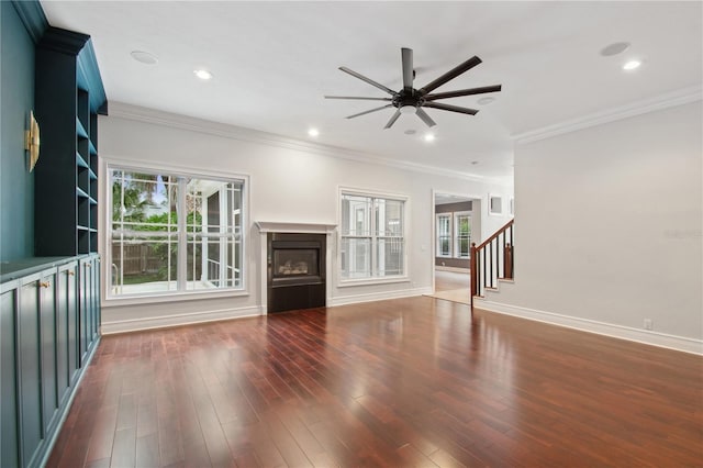 unfurnished living room with crown molding, plenty of natural light, dark wood-type flooring, and ceiling fan