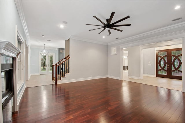 unfurnished living room featuring crown molding, french doors, dark wood-type flooring, and ceiling fan with notable chandelier