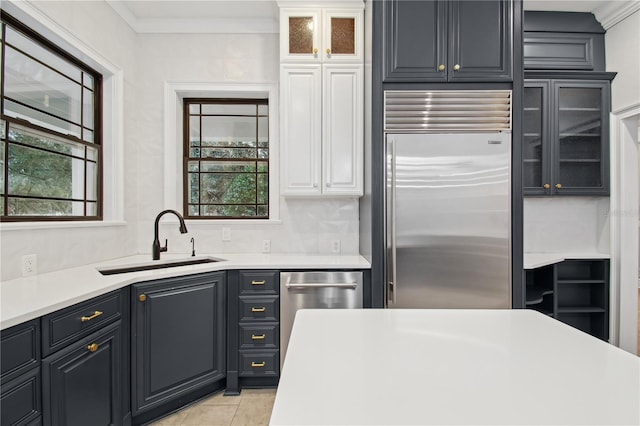 kitchen featuring a healthy amount of sunlight, ornamental molding, sink, and appliances with stainless steel finishes