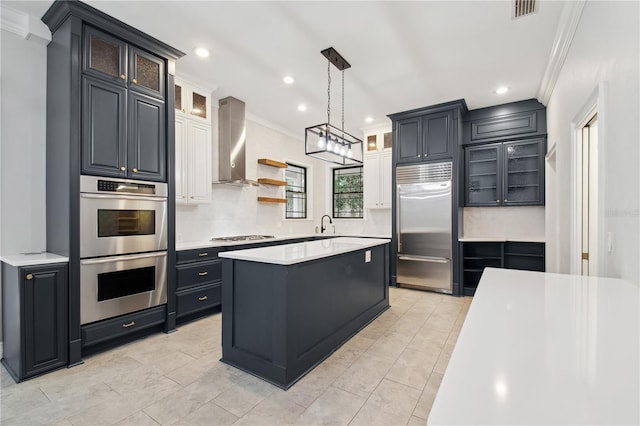 kitchen featuring appliances with stainless steel finishes, a kitchen island, crown molding, and wall chimney exhaust hood