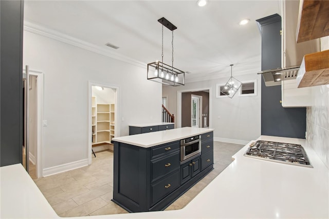 kitchen with decorative light fixtures, a kitchen island, and ornamental molding