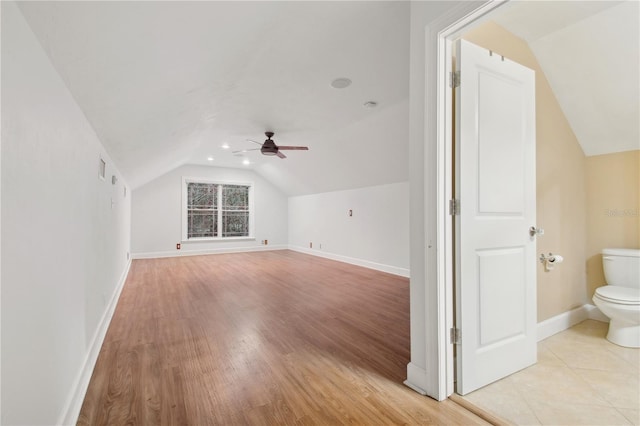 additional living space with vaulted ceiling, light hardwood / wood-style flooring, and ceiling fan