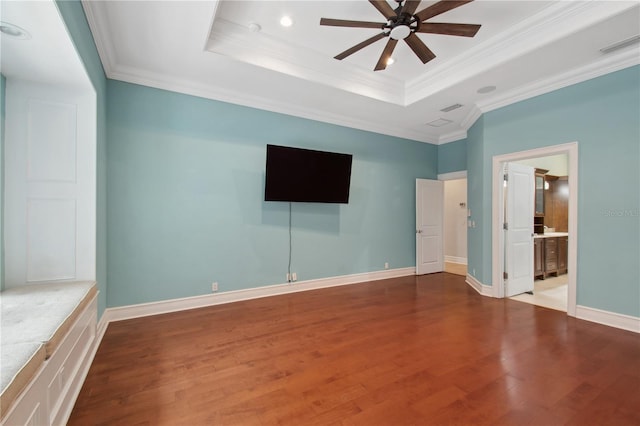 unfurnished bedroom with ensuite bathroom, a raised ceiling, hardwood / wood-style flooring, ceiling fan, and ornamental molding