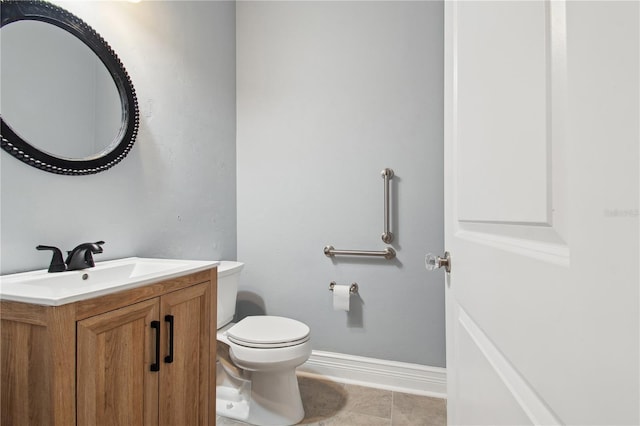 bathroom with tile patterned flooring, vanity, and toilet