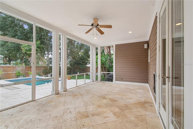 unfurnished sunroom with ceiling fan