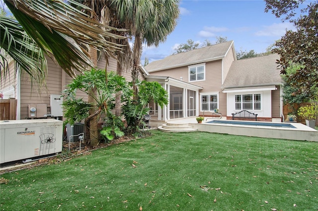 back of house featuring a patio, a lawn, an empty pool, and a sunroom