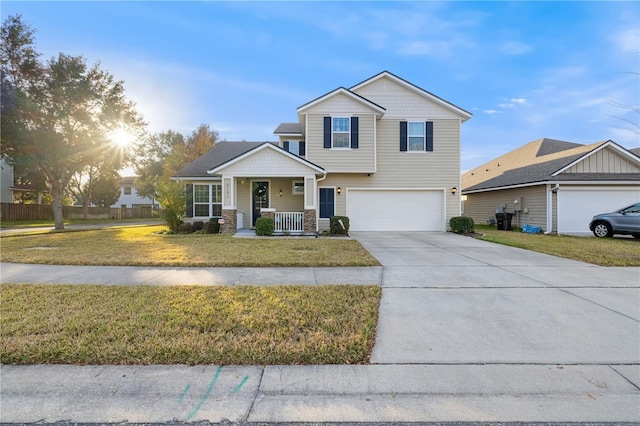 view of front of property featuring a front yard, a porch, and a garage