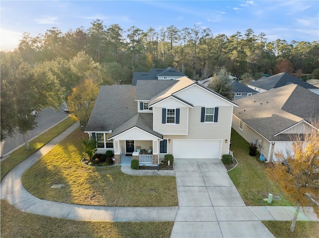 view of front facade featuring a porch, a garage, and a front lawn