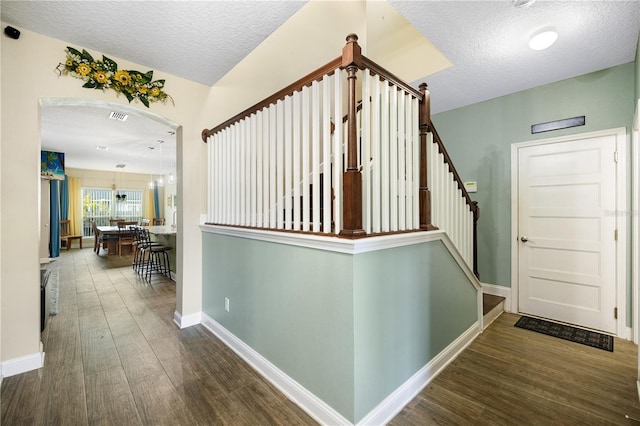 stairway with hardwood / wood-style floors and a textured ceiling