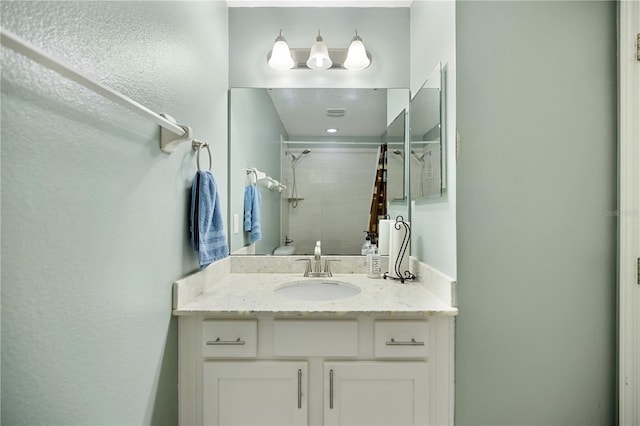 bathroom featuring vanity and tiled shower