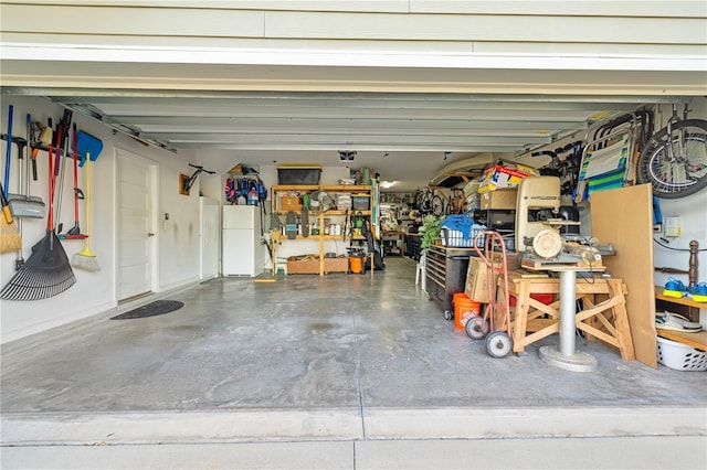 garage featuring white refrigerator and a workshop area