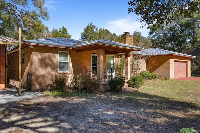 view of front facade with a garage, a porch, and a front yard