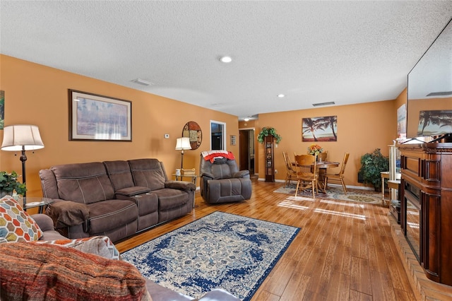 living room with hardwood / wood-style flooring and a textured ceiling