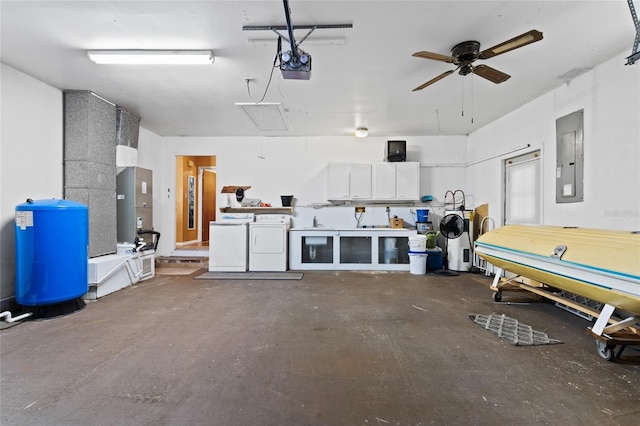 garage featuring a garage door opener, washing machine and clothes dryer, ceiling fan, and electric panel