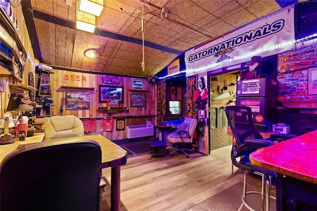 game room with a wall mounted AC and hardwood / wood-style floors