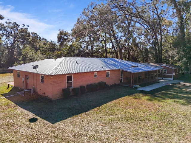 view of side of property with central AC unit and a lawn