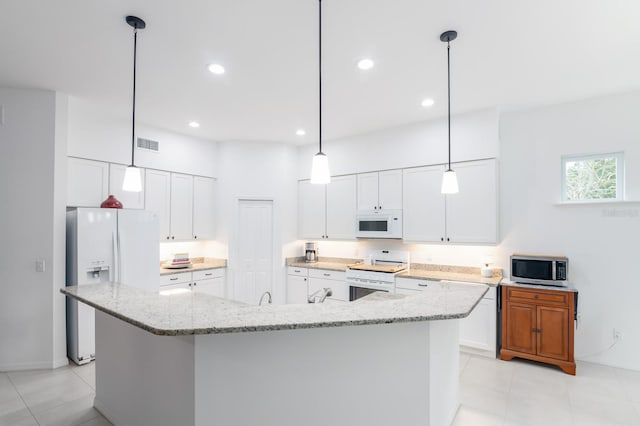 kitchen featuring a large island, white cabinetry, light stone counters, and white appliances